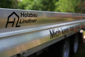 Foto von Anhängerbeschriftung mit Logo Holzbau Lindtner und einer Aufschrift
