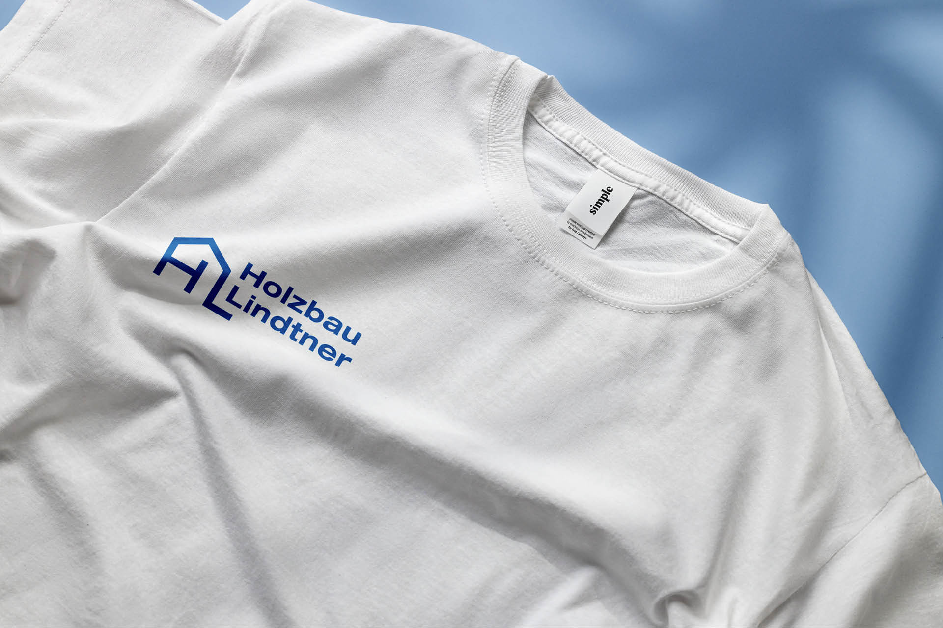 Mockup von weißen T-shirt mit Holzbau Lindtner Logo